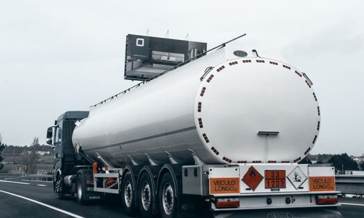 pexels-photo-36228061-36228061 Rear view of a large tanker truck transporting fuel on a highway, emphasizing logistics and transportation.